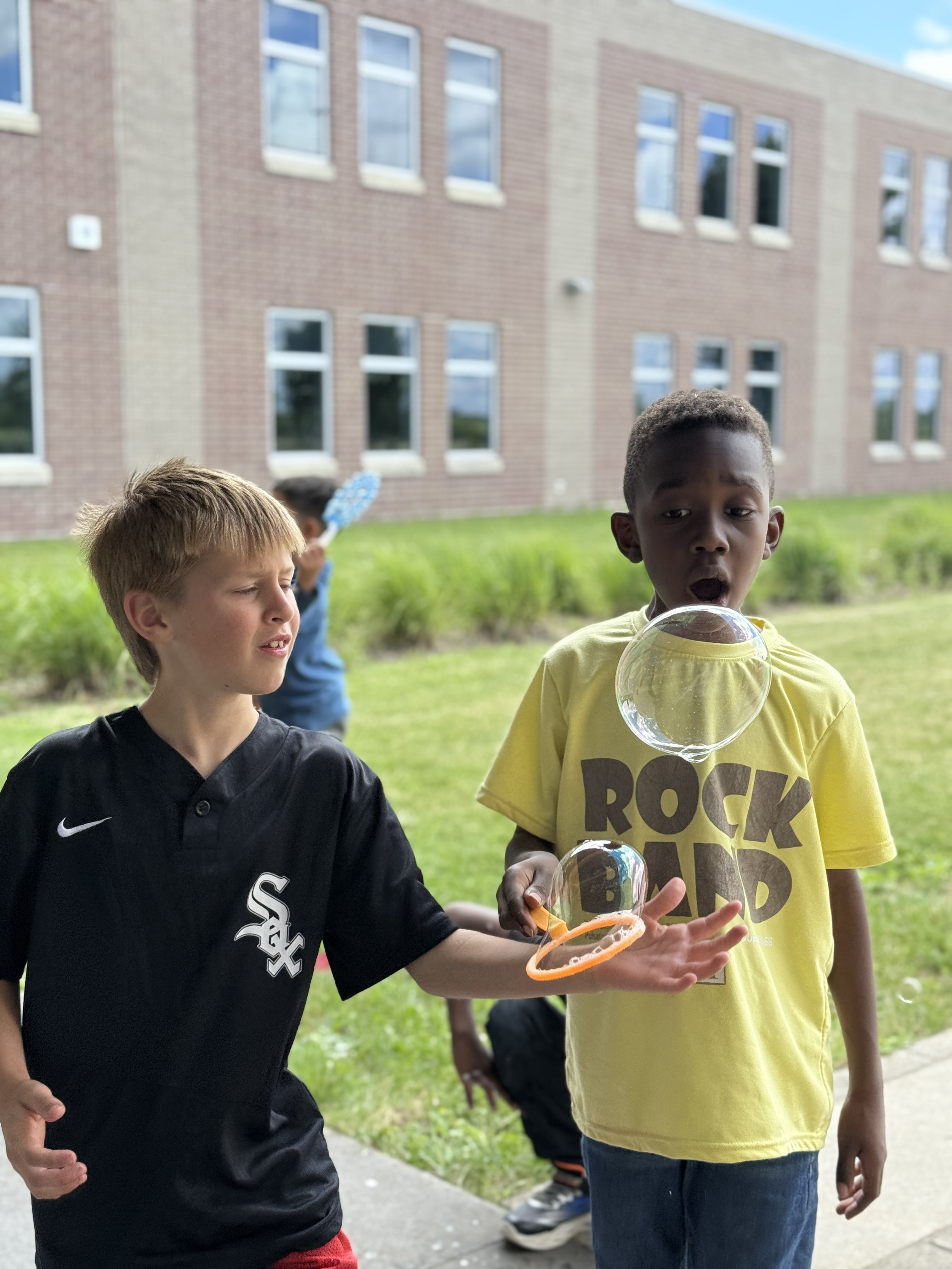 Children playing with bubbles outdoors during Neighborhood Centers Summer Camp